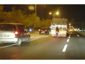 Tehlikeye aldırış etmeden bisikletiyle kamyonun arkasında seyretti