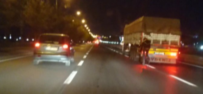 Tehlikeye aldırış etmeden bisikletiyle kamyonun arkasında seyretti