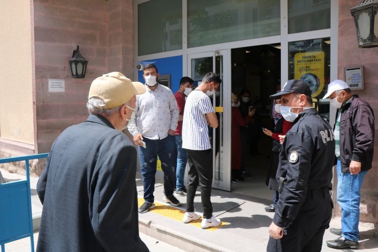 PTT önünde oluşan kuyrukta polisin şefkat eli