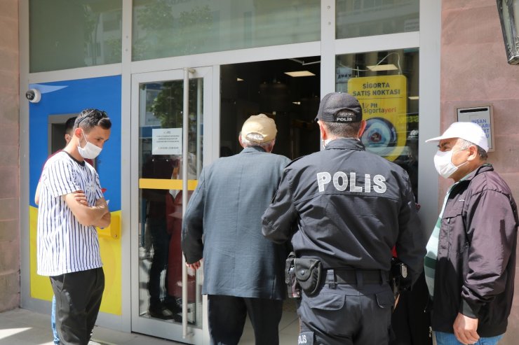 PTT önünde oluşan kuyrukta polisin şefkat eli