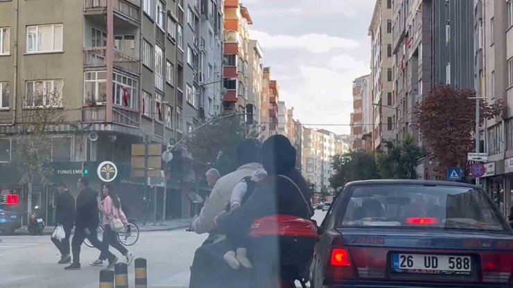 Kasksız kucağında bebekle kırmızı ışığa rağmen elektrikli bisiklet ile yoluna devam ettiler