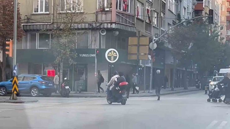 Kasksız kucağında bebekle kırmızı ışığa rağmen elektrikli bisiklet ile yoluna devam ettiler