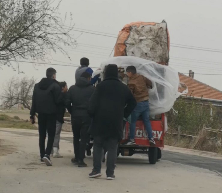 Şiddetli rüzgarda triportör devrilmesin diye üzerine binip gittiler